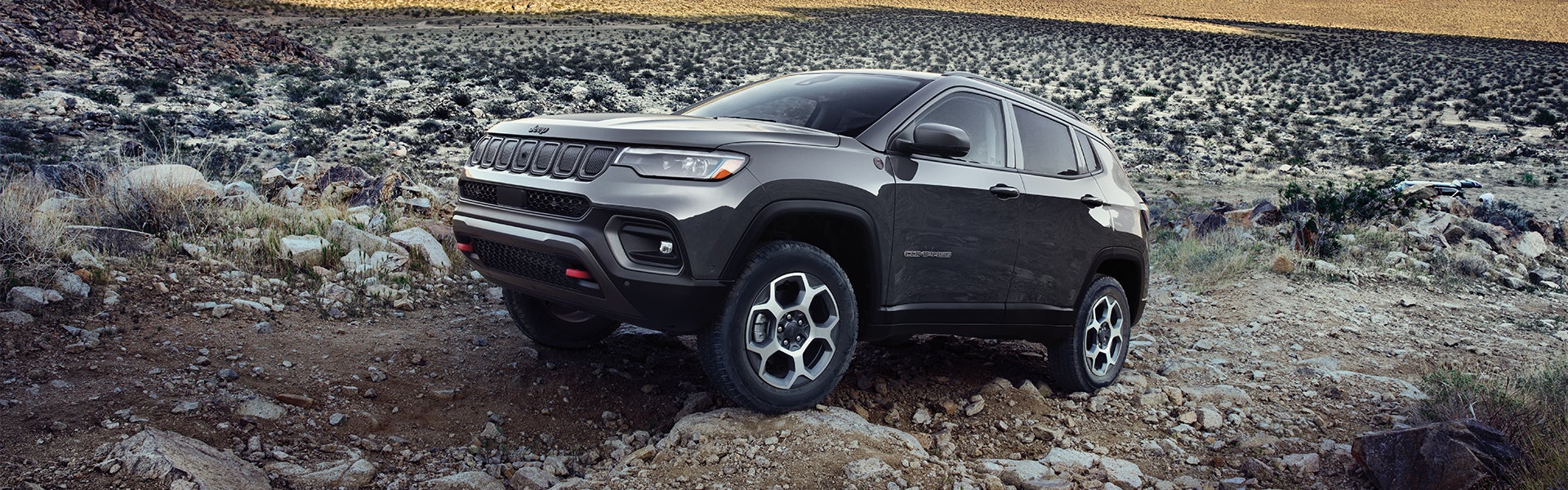 2023 Jeep Compass driving on rocky road